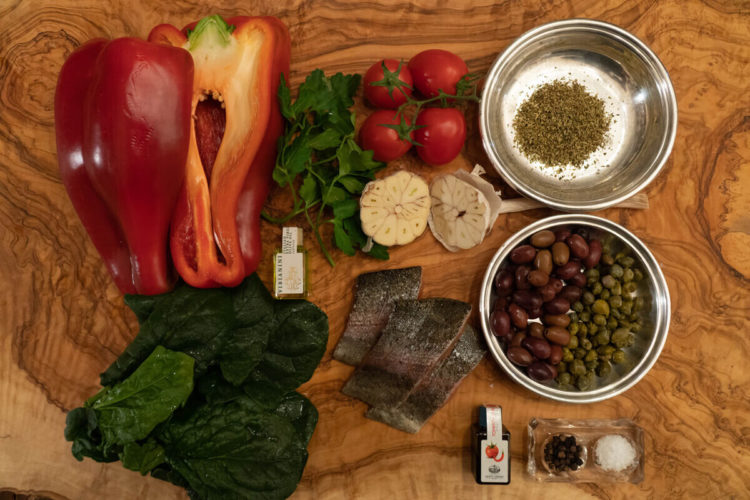 Trota, olive, pomodori e contorno di spinaci